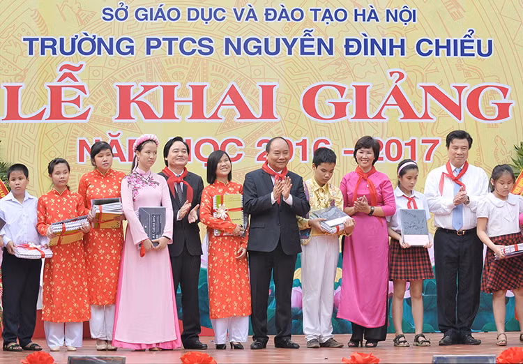 越南政府总理阮春福向河内市二征夫人郡阮廷沼初中学校贫困学生赠送礼物。