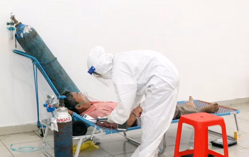 医生对患有基础性疾病的无症状患者进行看病。图自越通社