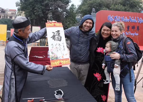 给外国游客赠送书法作品。（图片来源：越南《人民报》）