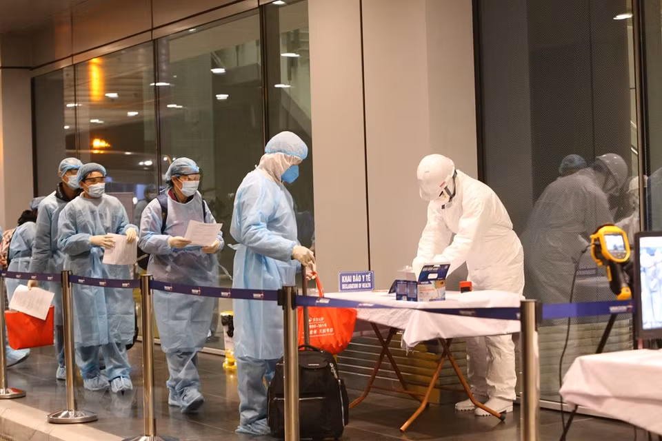 越南公民办理入境手续前进行消毒。越通社记者 杨江 摄