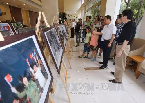  越通社副社长黎维传和与会代表参观图片展。（图片来源：越通社）