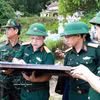 顺化市军事指挥部副政委河文爱大校（左三）在地图上确定烈士安葬位置。图自越通社