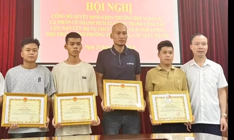 四名青年因勇敢救助火灾中受困人员而获得纸桥郡人民委员会的奖状。图自越通社