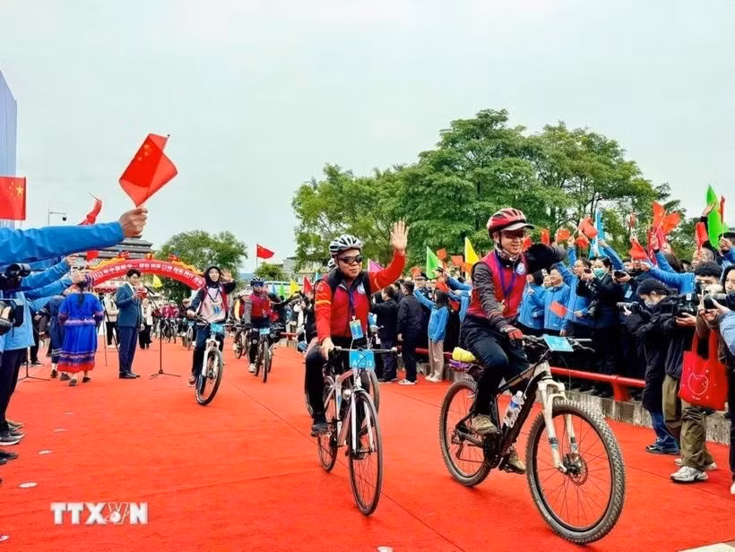 附图：题为"跨境骑行，友谊同行"的自行车友谊赛。图自越通社
