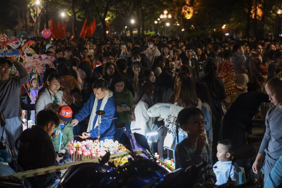 众多市民选择在还剑湖周边有利位置守候，等待观赏迎接2026年的新年烟花表演。图自 越通社
