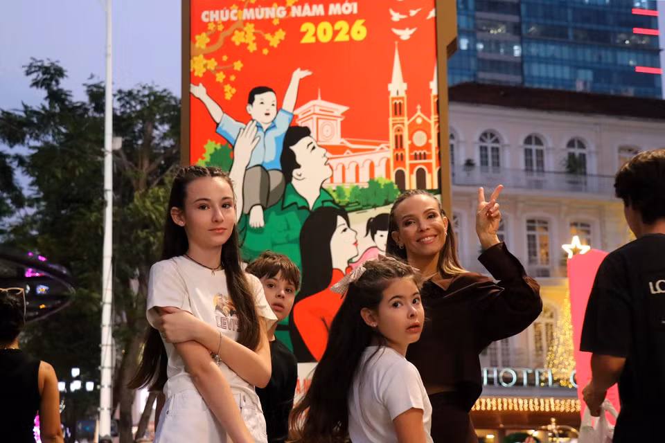众多市民和游客在阮惠步行街花卉景观前拍照留念。图自 越通社