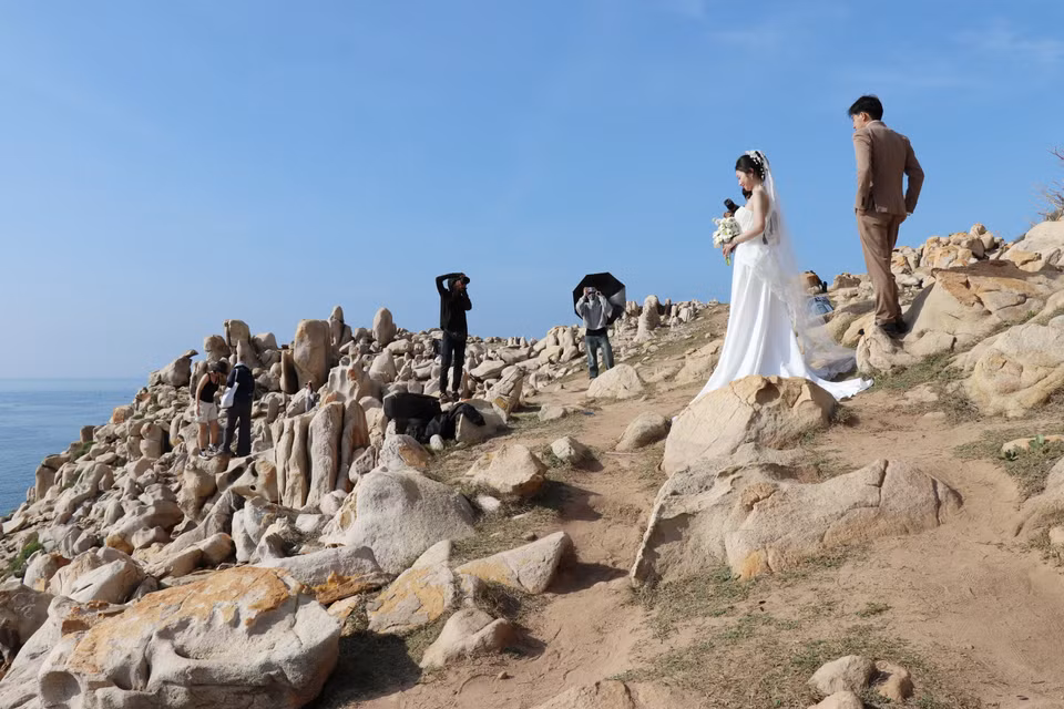 游客在宁顺省宁海县永海乡的主山国家公园岩石公园内拍照留影，记录下这片奇岩美景带来的震撼与感动。图自 越通社