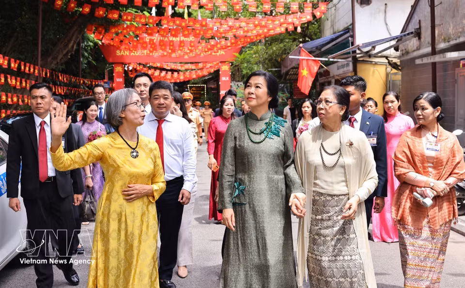 苏林夫人吴芳璃与敏昂莱总统夫人杜久久拉探访万福丝绸村。图自 越通社