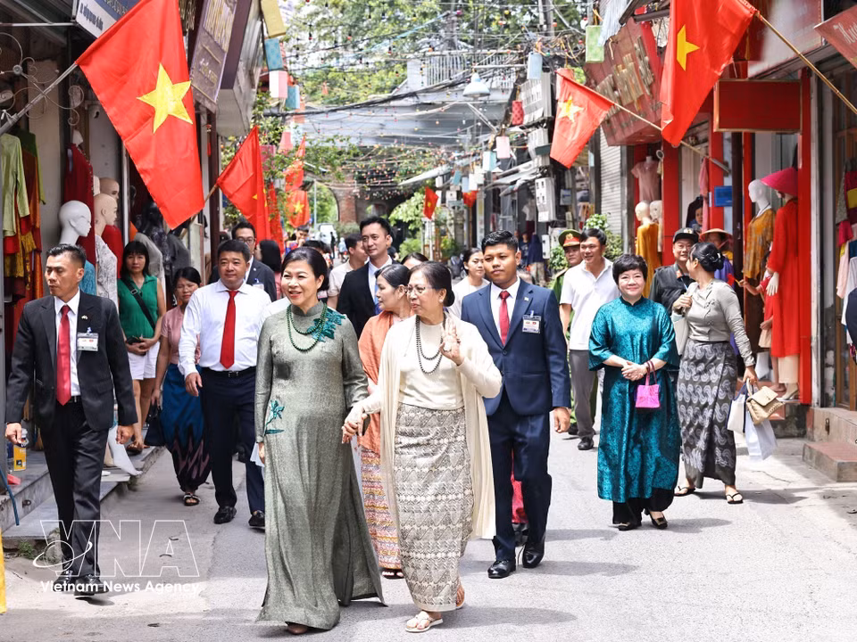 苏林夫人吴芳璃与敏昂莱总统夫人杜久久拉探访万福丝绸村。图自 越通社