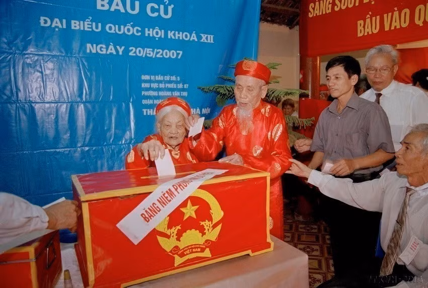 两位年逾百岁的高领选民在第5选区第7投票站参加2007年5月20日第十二届国会代表选举。图自 越通社