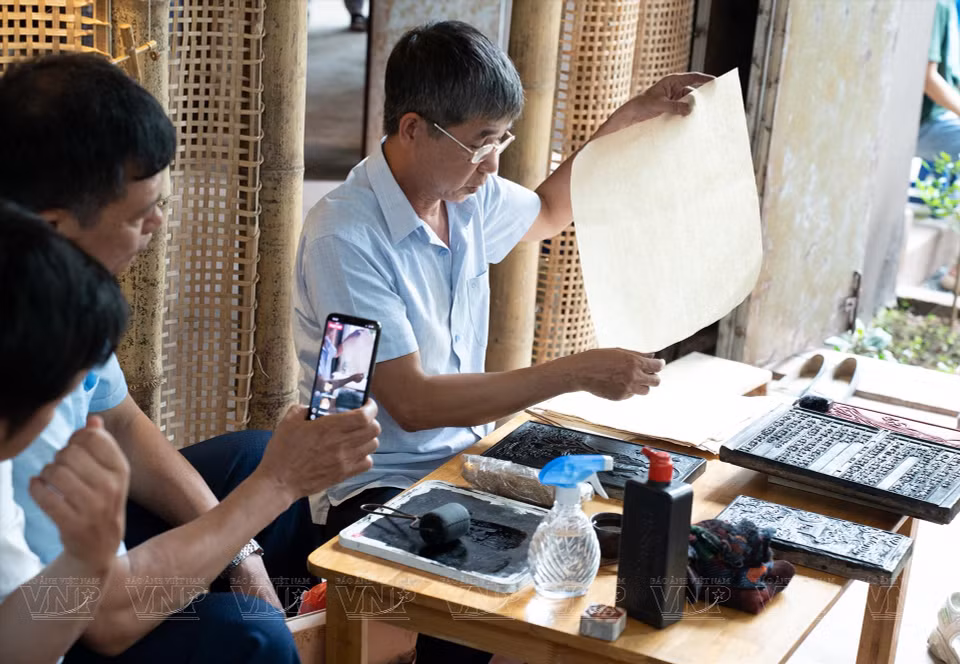 参观者亲眼目睹传统手工艺品的制作过程。图自越通社