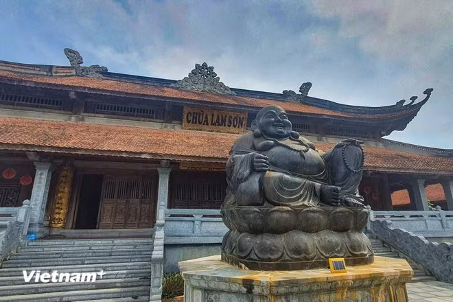 寺庙庭院中央有一尊由整块石头雕刻而成的巨型石雕弥勒佛。图自 越通社《Vietnam+》