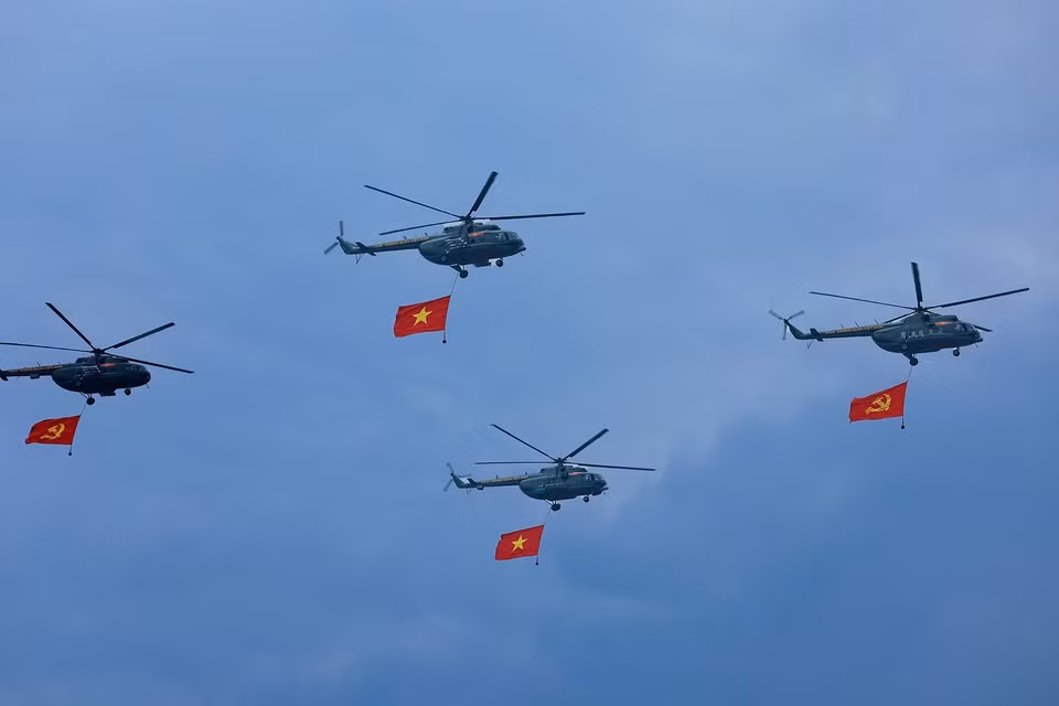 直升机悬挂越南共产党党旗、国旗，飞过礼台。图自 越通社
