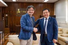 越南驻巴西大使裴文毅与南里奥格兰德联邦大学（UFRGS）副校长佩德罗·德·阿尔梅达·科斯塔亲切握手。图自越通社