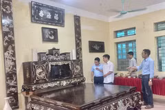 专美社手工艺人向游客介绍其家族价值30多亿越盾的螺钿镶嵌及磨漆榻床、橱柜和横披对联。图自越通社