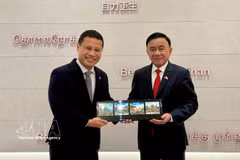 越共中央政治局委员、中央书记处常务书记陈锦秀与新加坡人民行动党主席、政府教育部长李智陞互送纪念品。图自越通社