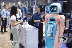参观者在Qualcomm展台了解老年人护理机器人模型。图自越通社