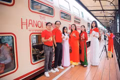 国旗的红色与带有越南标志的服饰为“河内五城门”列车的体验之旅增添色彩。图自《投资报》