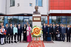 国会主席陈青敏偕夫人及代表们在以胡志明主席命名的第14学校内的胡志明主席雕像前合影留念。 图自越通社