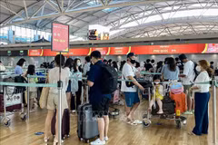 游客在韩国仁川国际机场排队办理飞往越南富国岛的登机手续。图自越通社