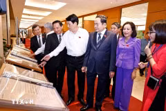 越南国家主席梁强和国会主席陈青敏参观《国会日报与第一届大选》专题展。图自越通社