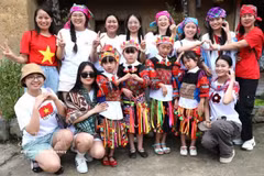 游客在宣光省龙鼓乡与当地倮倮族小朋友合影留念。图自越通社