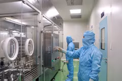 IVAC研究院的研究人员在疫苗生产流程中操作设备。图自越通社