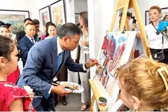 画家吴德煌在8月15日的展览现场演示在鼠皮纸上作画。图：越通社发