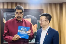 马杜罗总统接收由阮祥林赠送的《世界人民对胡志明主席的感情》（西班牙语版）书籍。图自越通社