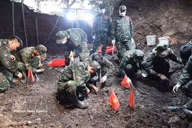 K74队干部、战士在刚发现的烈士集体墓区域展开烈士遗骸搜寻、归集工作。图自越通社