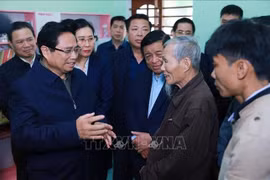 越南政府总理范明政走访慰问广义省消除危旧房项目中的一户家庭。图自越通社