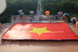 巨幅国旗面积2025平方米，长60米，宽33.75米，重约320公斤，采用超耐用布料制成。图自越通社