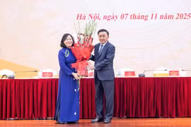 越共中央政治局委员、中央书记处常务书记陈锦绣向越共中央政治局委员、中央书记处书记、越南祖国阵线中央委员会主席裴氏明怀献花祝贺。图自越通社