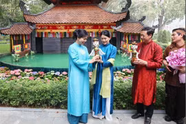 越共中央总书记夫人与新加坡总理夫人共赏水上木偶戏。图自越通社