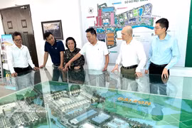 企业家阮怀北（右三）正在向参观者介绍由其担任投资方的大山都市区模型。图自越通社