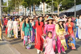 同塔省妇女举行游行，颂扬传统奥黛的美丽。图自越通社