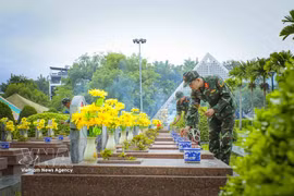奠边省军事指挥部战士在对A1烈士陵园英烈陵墓发掘取样前向各位英烈进香。图自越通社