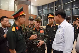 越南代表团团长范文巳少将和仰光省首席部长吴梭登进行交谈。图自越通社