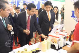 代表们参观越南企业的展位。图自越通社