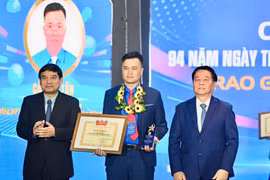 越共中央政治局委员、中央书记处书记、中央宣教与民运部部长阮仲义与越南国会文化教育委员会主任阮德荣为李自仲奖获奖者颁奖。胡志明共青团中央委员会供图