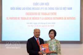 越南通讯社党委书记、社长、中央宣教部副部长武越庄向墨西哥劳动党总书记、参议员阿尔贝托·阿纳亚·古铁雷斯赠送关于越南革新40年的画册。图自越通社
