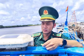 干豪边防检查站站长潘明王少校对渔船VMS设备进行检查。图自越通社
