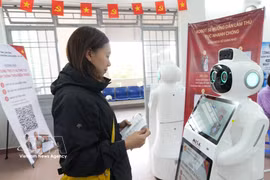 在春香坊（林同省）公共行政服务中心，居民与人工智能机器人互动，获取有关行政手续办理的指引。图自越通社