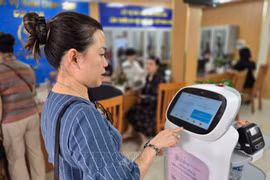 人民体验河内市南门坊人工智能机器人服务。图自越通社