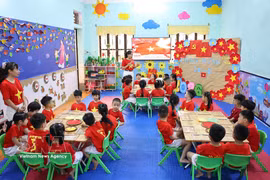 宣光省河江2坊玫瑰幼儿园的师生们共同纪念越南南部解放和国家统一51周年。图自越通社