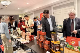 加拿大企业代表了解越南咖啡产品。图自越通社
