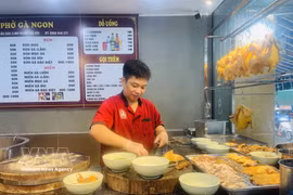 厨师正在为顾客准备鸡肉河粉。图自越通社