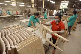 附图：铁丹有限公司工厂内工人正在完善准备出口的木制家具产品。图自越通社