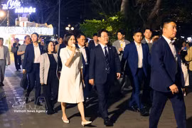 韩国总统夫人手拿冰淇淋漫步在河内街头的人群中。图自越通社