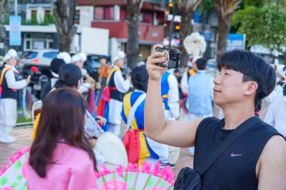 游行活动的多彩之美吸引众多市民和游客纷纷用手机记录精彩瞬间。图自Vietnam+